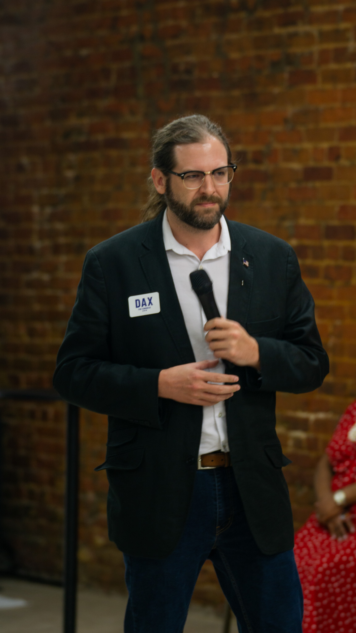 Candidate holding microphone against brick wall mid-thought