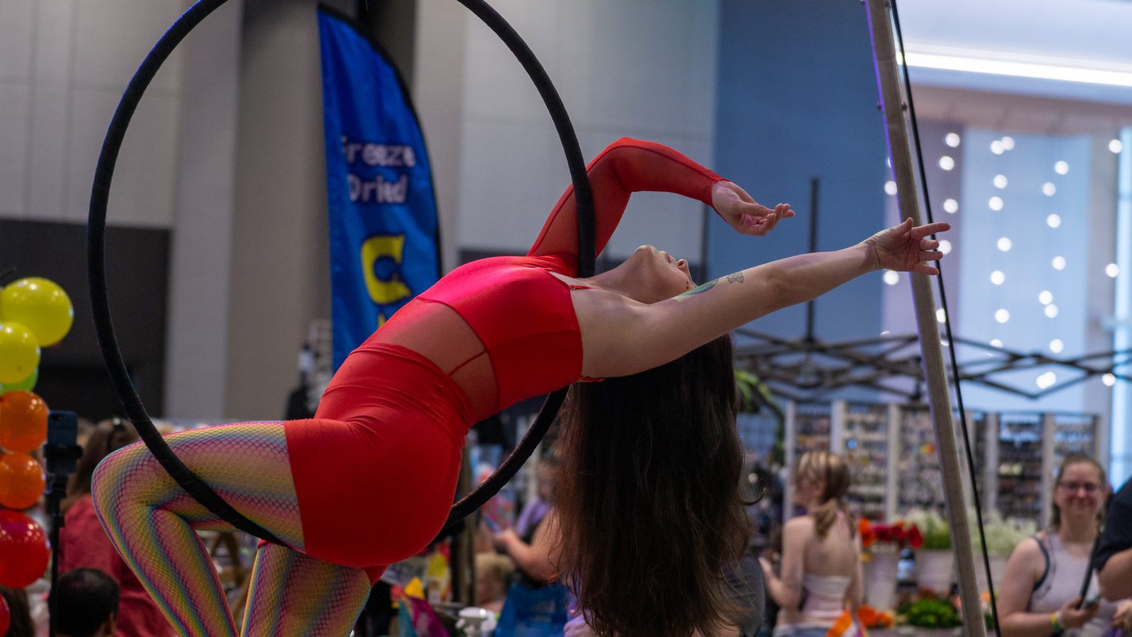 Dancer in red striking a dramatic pose with arms outstretched