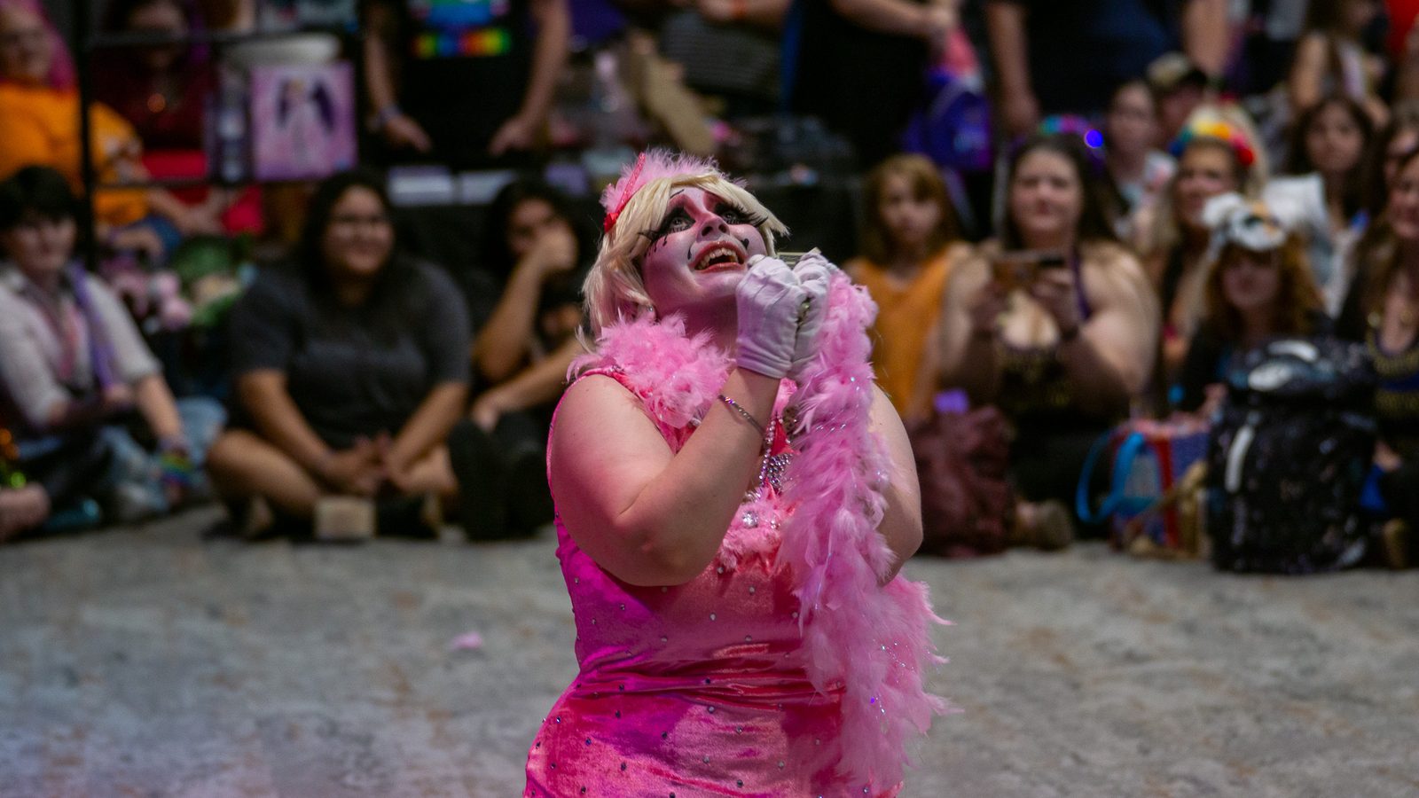Performer in a pink boa working the audience