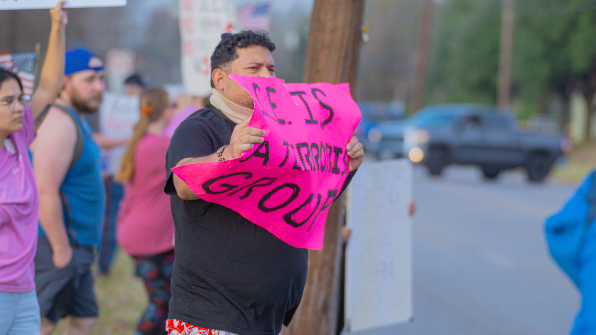 Protester with pink ICE Is A Terrorist Group sign