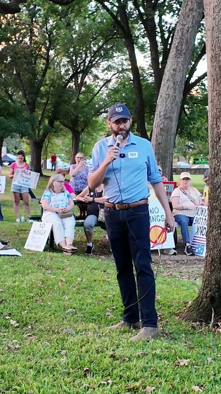 Dax Alexander speaking into a microphone at a No Kings rally